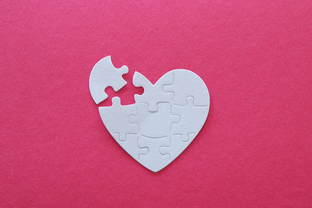 Top view image of paper white heart puzzle with missing piece over pink background. Health care, donate, world heart day and world health day concept - Photo, Image