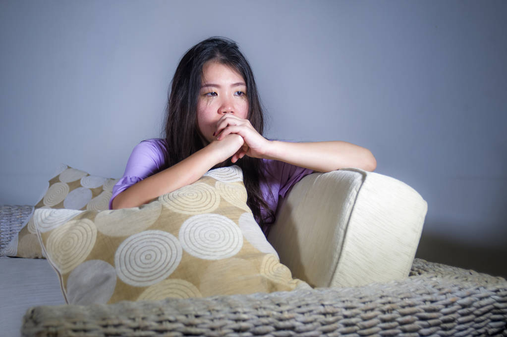 junge traurige und depressive asiatische Koreanerin zu Hause Sofa Couch weint verzweifelt und hilflos leiden Angst und Depression Gefühl Schmerz in der Beziehung und einsam Leben Problemkonzept - Foto, Bild