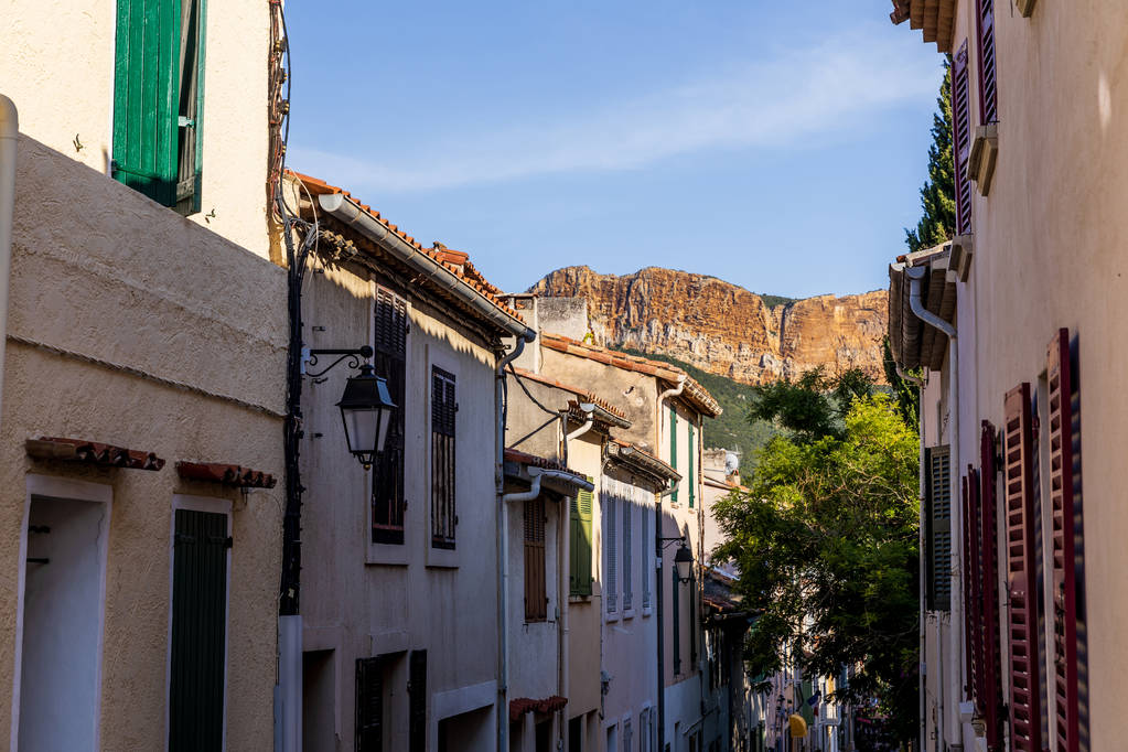 viihtyisä kapea katu perinteisiä taloja ja kaukana kallioiset vuoret Provencessa, Ranskassa
 - Valokuva, kuva