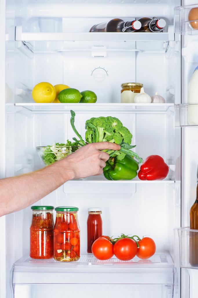 immagine ritagliata di uomo che prende broccoli dal frigorifero
 - Foto, immagini