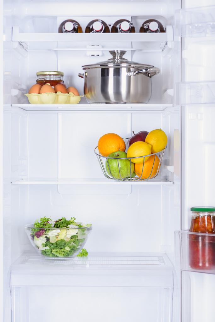 rijpe vruchten, salade, pan en eieren in de koelkast  - Foto, afbeelding