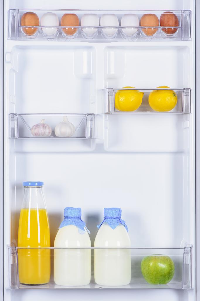яйца, чеснок, лимоны, сок и молоко в холодильнике
 - Фото, изображение