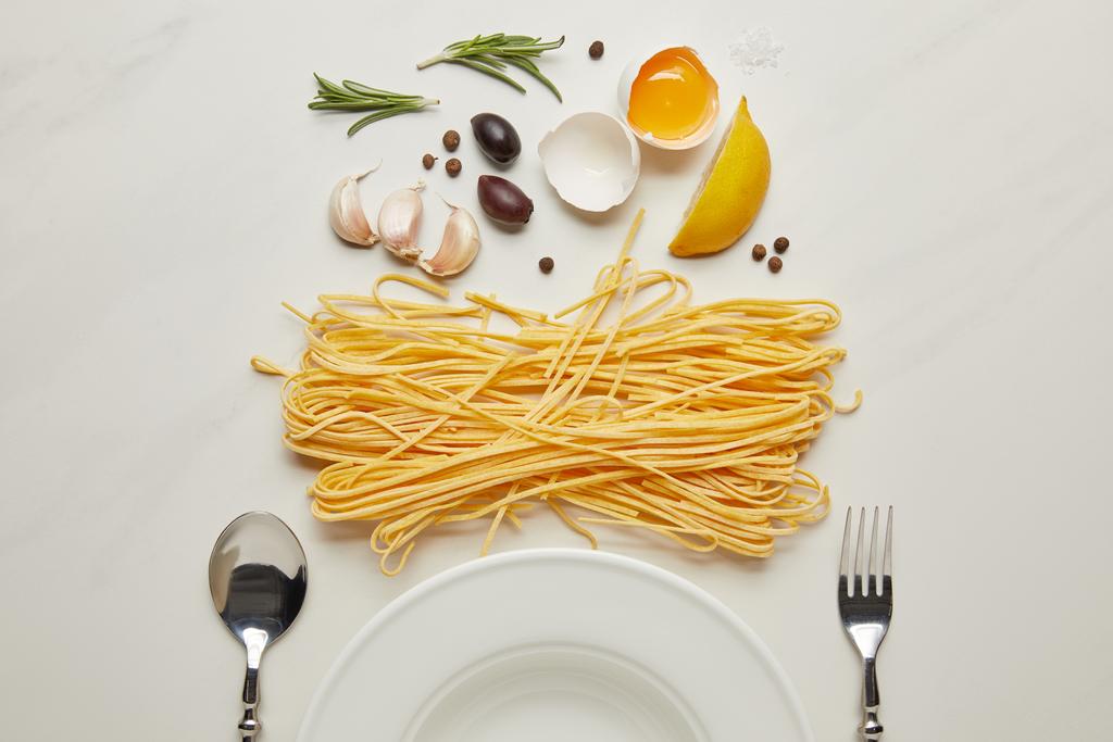 плоский слой с пустой тарелкой и ингредиентами пасты на поверхности белого мрамора
 - Фото, изображение