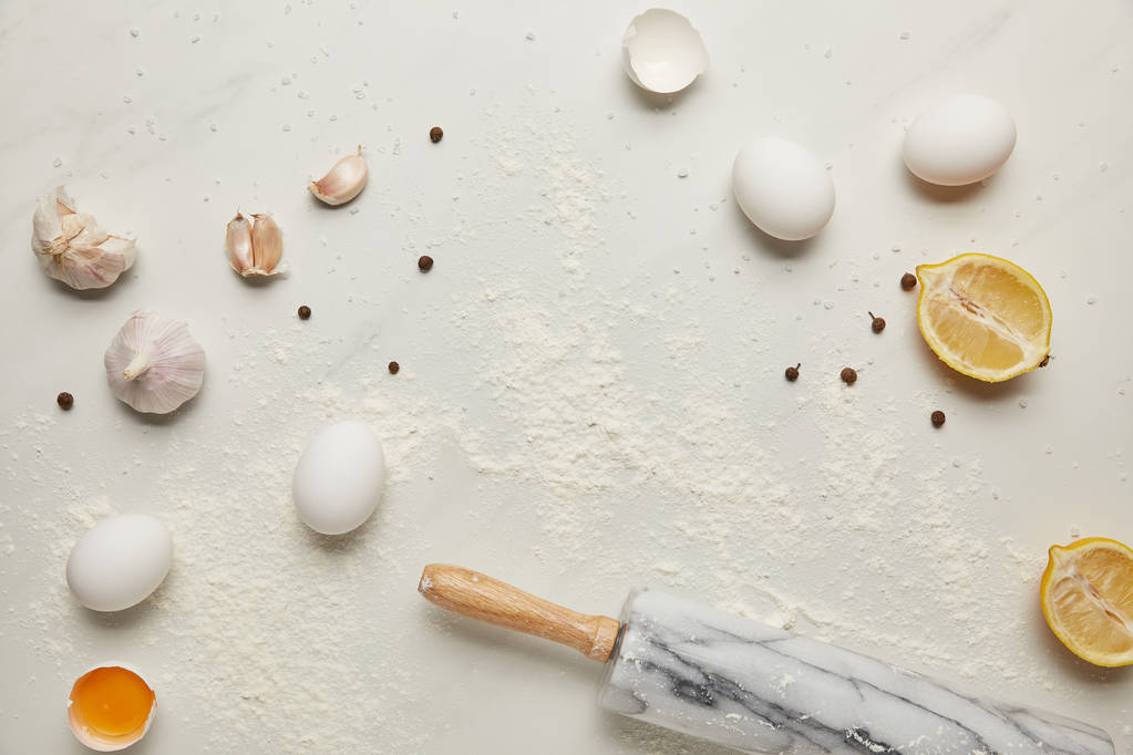tendido plano con rodillo e ingredientes para pasta italiana dispuestos en la mesa de mármol blanco
 - Foto, Imagen
