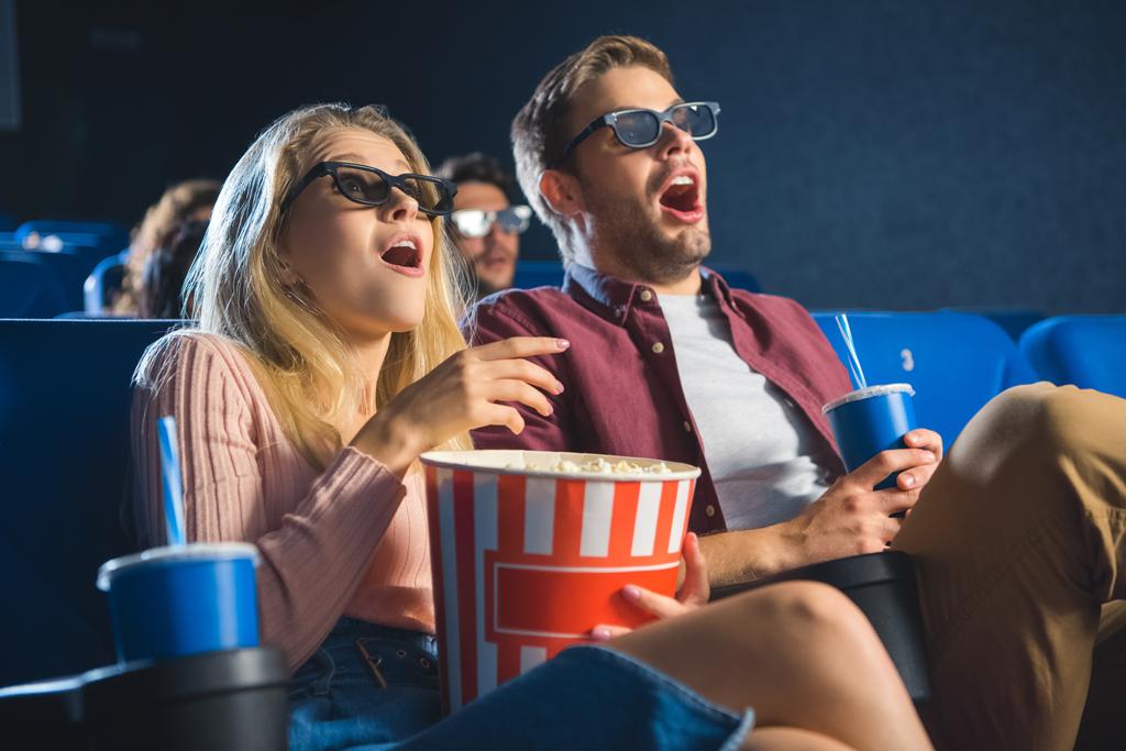 shocked couple in 3d glasses with popcorn watching film together in cinema - Photo, Image