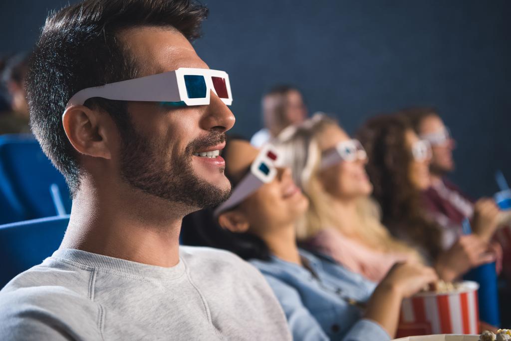 Selektiver Fokus multiethnischer Freunde in 3D-Gläsern mit Popcorn im Kino - Foto, Bild