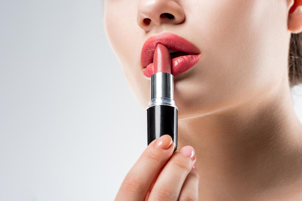 vue partielle de fille appliquant rouge à lèvres rose, isolé sur blanc
 - Photo, image