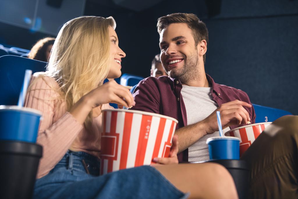 napój wesoły para z popcornem i napojami orzeźwiającymi razem oglądania filmu w kinie - Zdjęcie, obraz