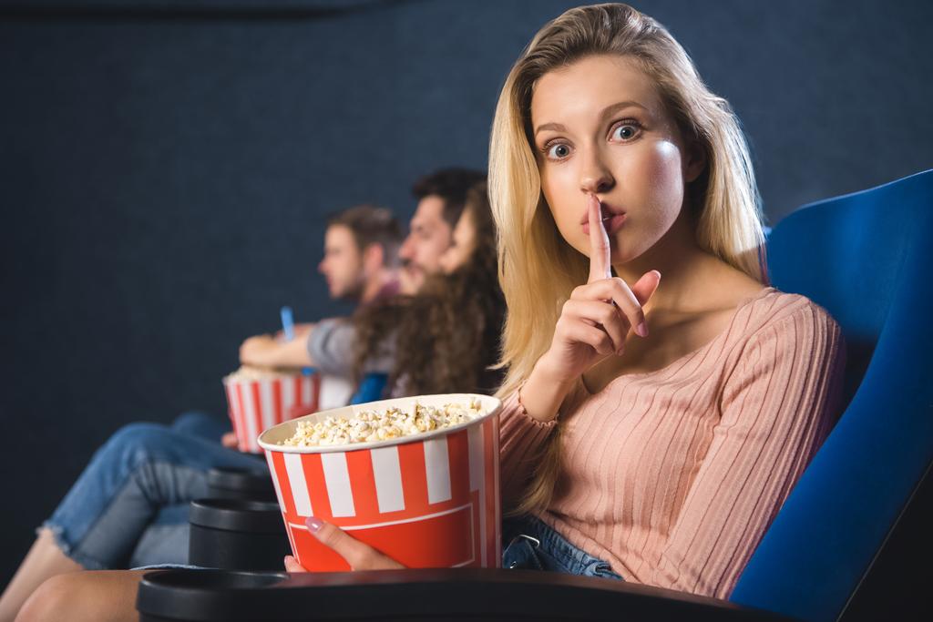 selectieve aandacht van vrouw met popcorn weergegeven: stilte ondertekenen in bioscoop - Foto, afbeelding