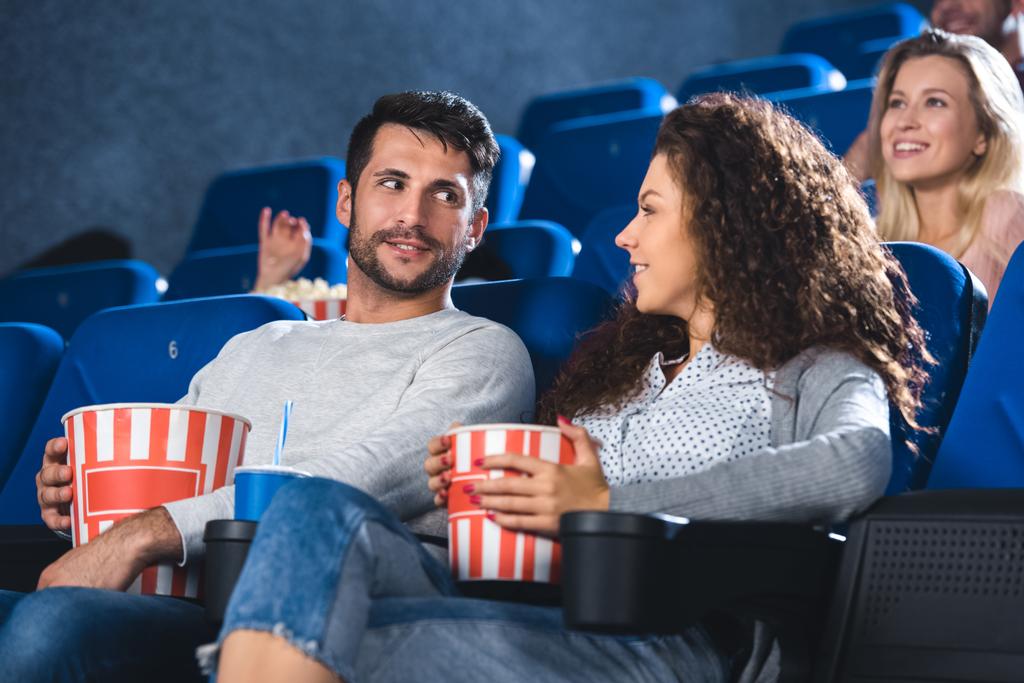 couple with popcorn and soda drink watching film together in cinema - Photo, Image