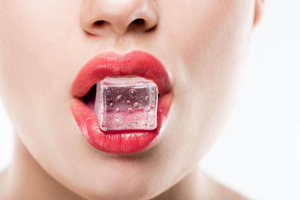 vista recortada de la mujer sosteniendo cubo de hielo en los labios, aislado en blanco
 - Foto, imagen