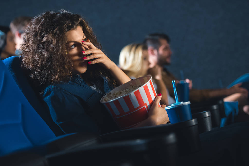 映画館で映画を見ながら目を覆っているポップコーン怖い女 - 写真・画像