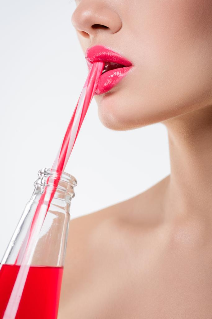 vista da vicino della ragazza che beve bevanda rosa dalla bottiglia con paglia, isolata su bianco
 - Foto, immagini