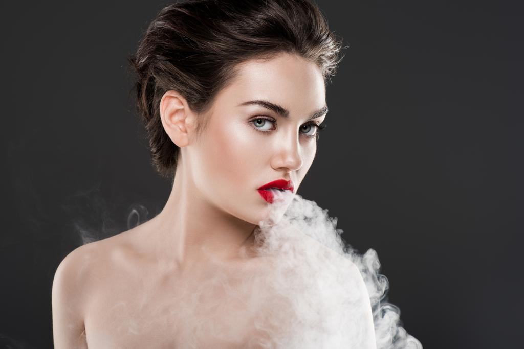 bella donna nuda vaporizzando e soffiando fumo, isolato su grigio
 - Foto, immagini