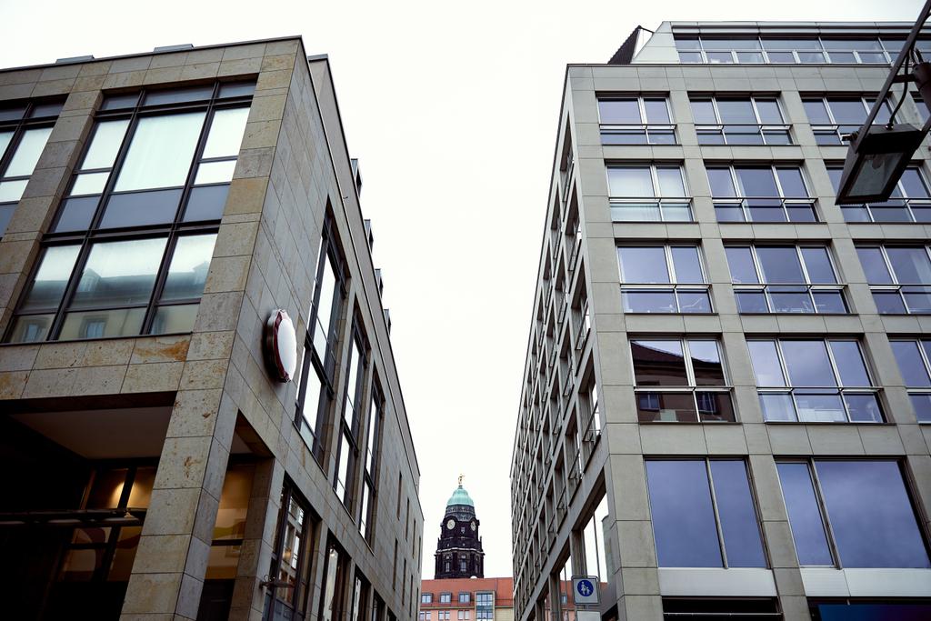 nízký úhel pohledu staré historické věže s hodinami mezi moderních budov v Drážďanech, Německo - Fotografie, Obrázek
