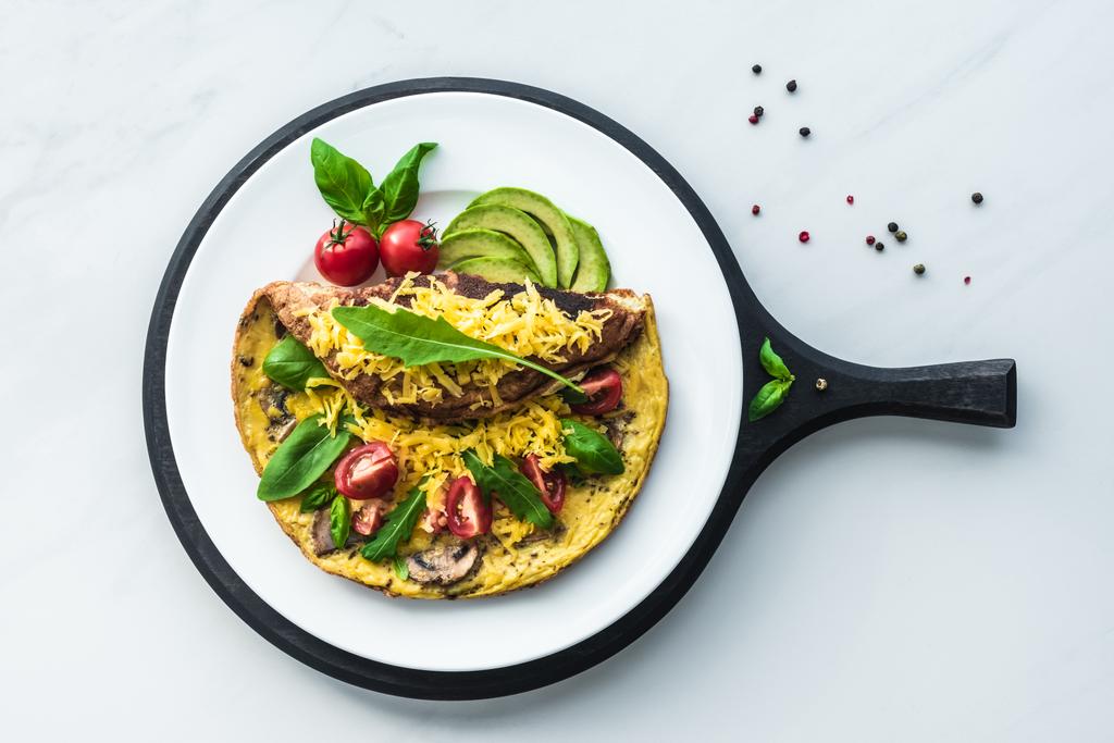 food composition with healthy omelette on wooden board on white marble tabletop - Photo, Image