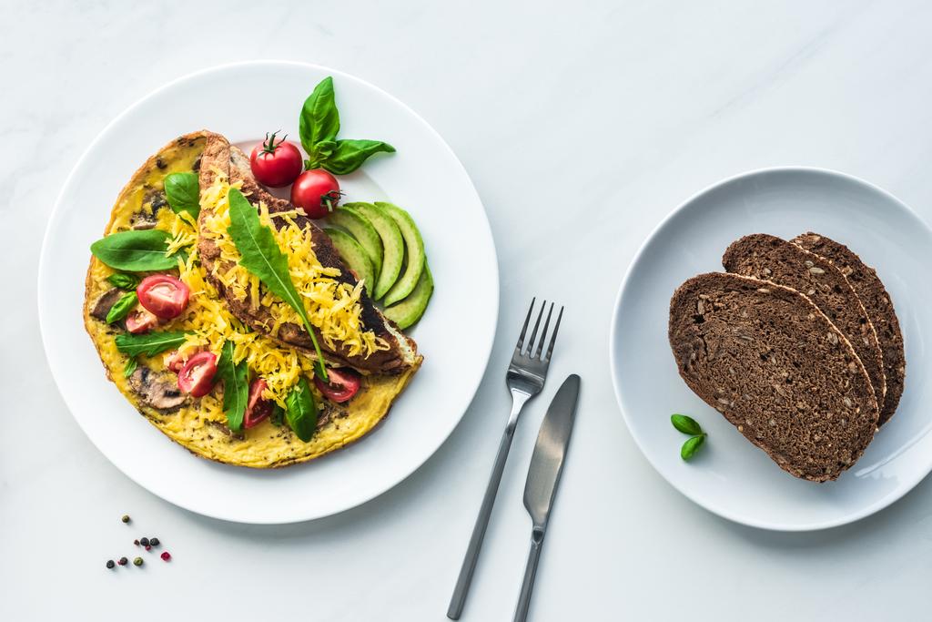pohled shora domácí omeletu a chléb k snídani na bílý mramor povrch - Fotografie, Obrázek
