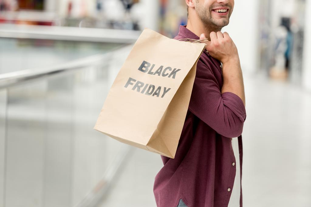 částečný pohled člověka drží papír s nápisem černý pátek na nákupní centrum  - Fotografie, Obrázek