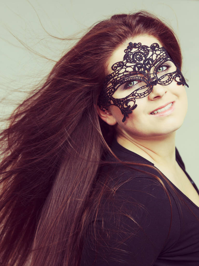 Щаслива гарненька таємнича жінка в шнуровій масці з довгим коричневим волоссям
. - Фото, зображення