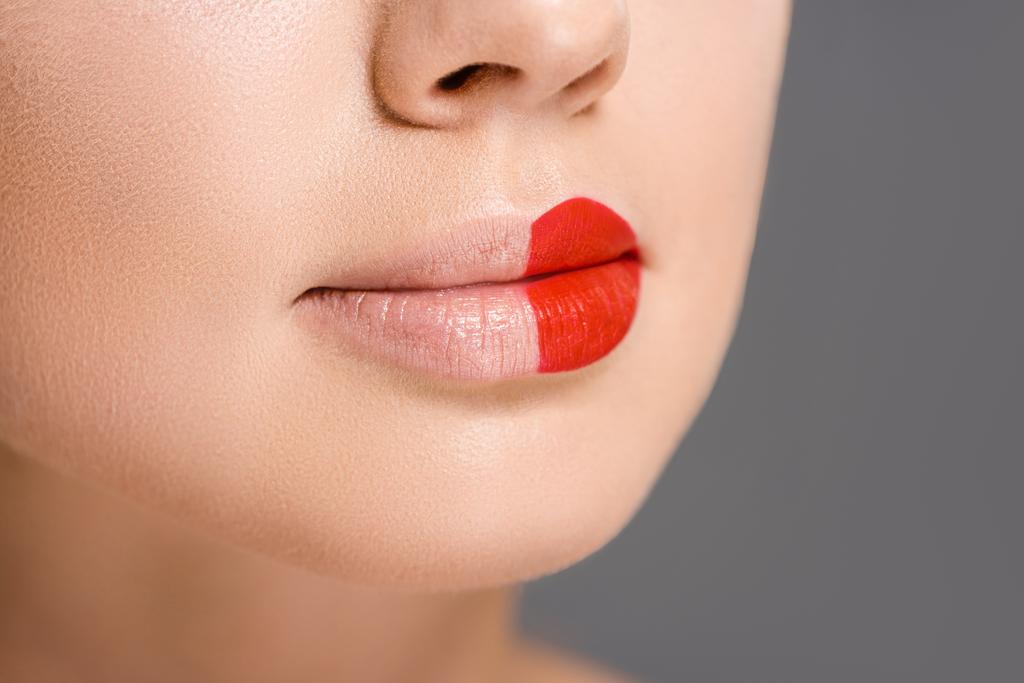 plan recadré de la femme avec rouge à lèvres sur la moitié de la bouche isolé sur gris
 - Photo, image