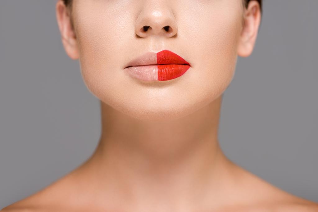 colpo ritagliato di donna con rossetto rosso su metà bocca isolato su grigio
 - Foto, immagini