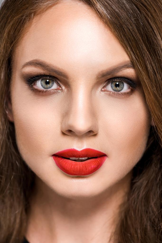 Porträt einer attraktiven jungen Frau mit rotem Lippenstift auf den Lippen, die in die Kamera blickt - Foto, Bild