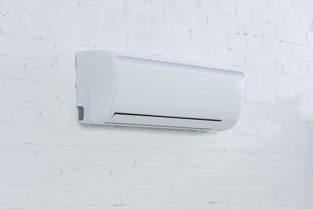close-up shot of air conditioner hanging on brick wall - Photo, Image