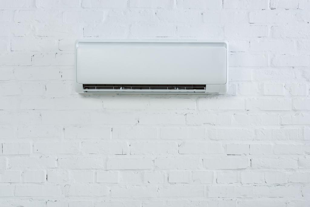 edessä näkymä ilmastointilaite roikkuu valkoinen tiili seinään
 - Valokuva, kuva