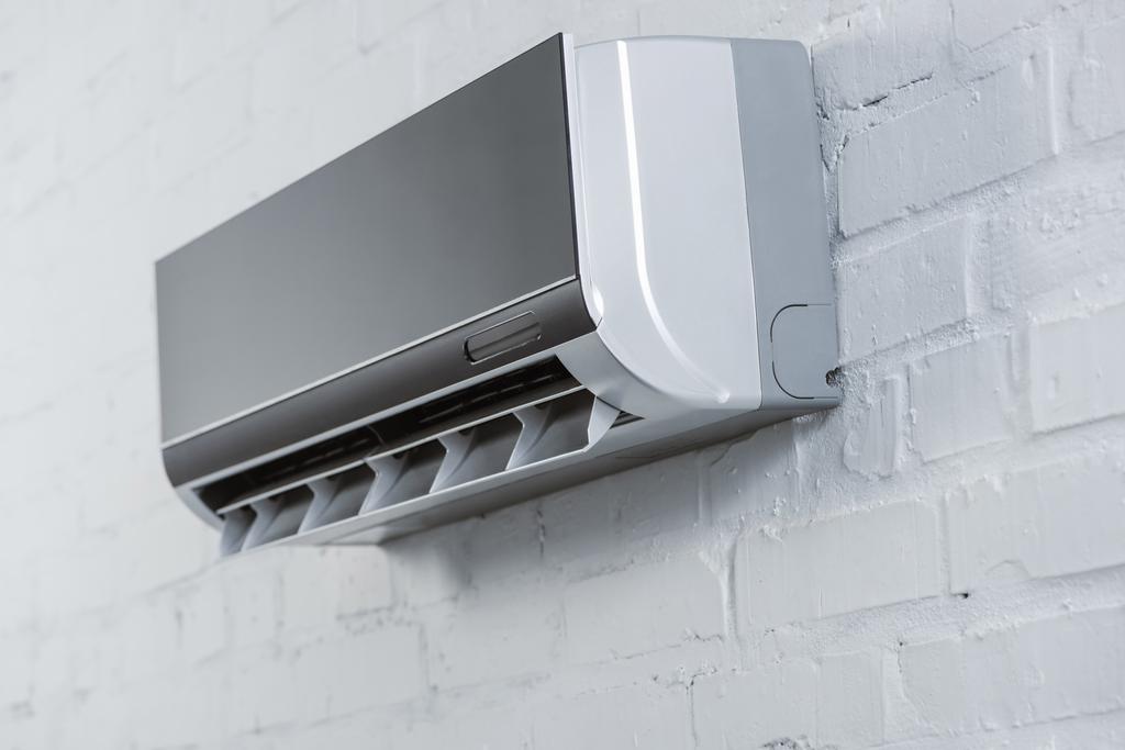 close-up shot of modern air conditioner hanging on white brick wall - Photo, Image