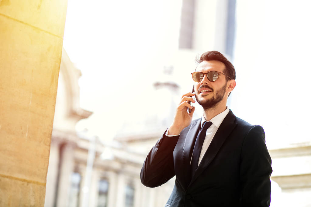 elegáns stílusos ember, sikeres üzletember, beszélget a mobiltelefon kívül közepén egy metropola egy üzleti tárgyalás előtt - Fotó, kép