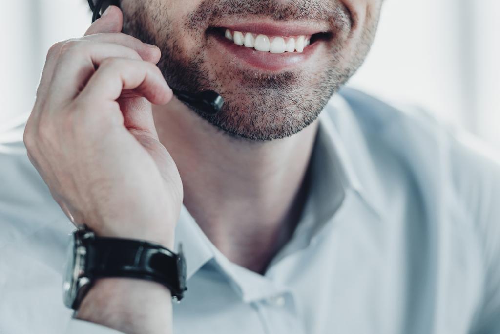 bijgesneden schot van glimlachen support hotline werknemer bedrijf microfoon - Foto, afbeelding