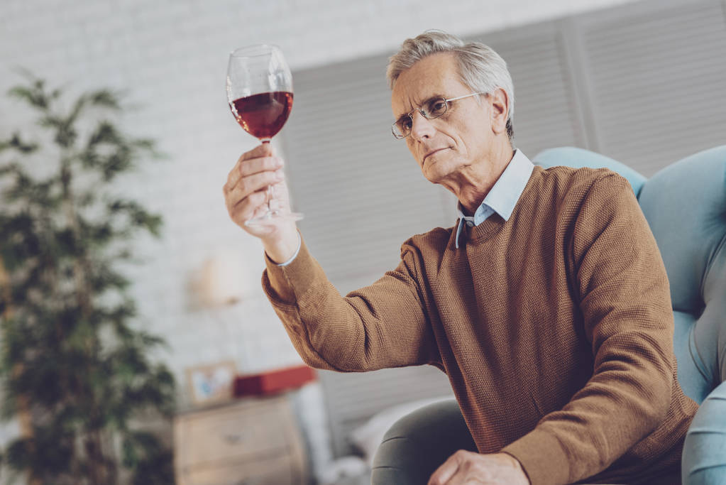 Poważny człowiek dojrzały badanie wina - Zdjęcie, obraz