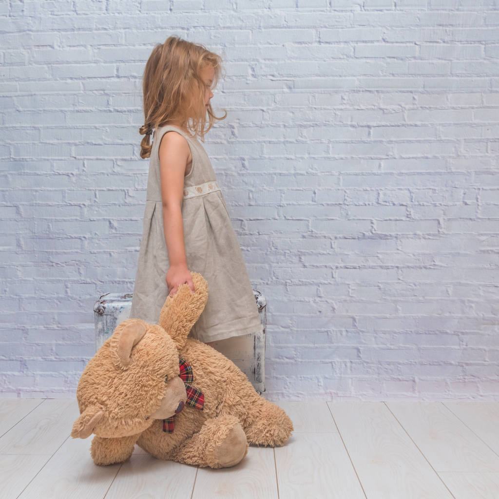 niña, bebé en vestido sobre fondo de pared de ladrillo blanco con maleta, con oso de juguete
 - Foto, imagen