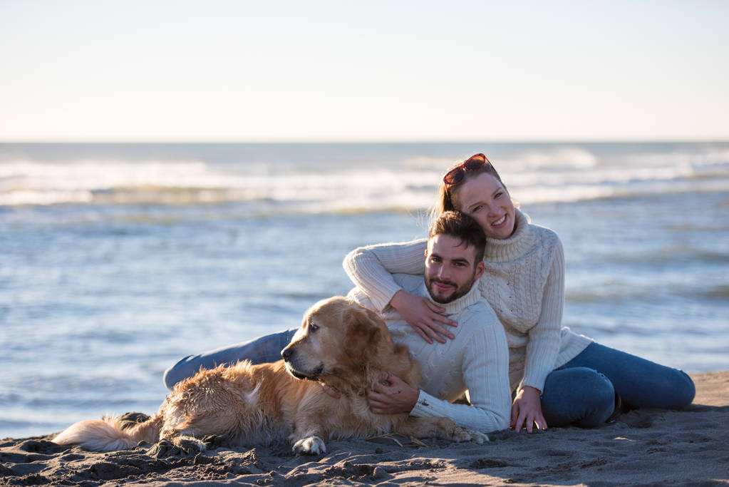 Pár se psem užívají čas spolu na pláži na podzim - Fotografie, Obrázek