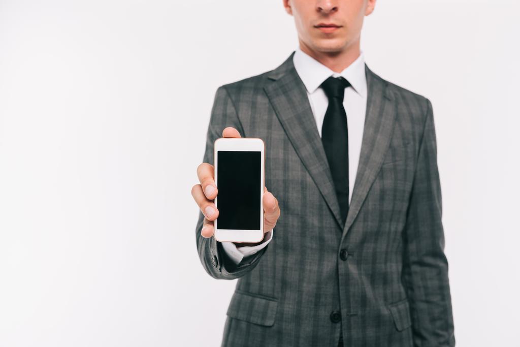 abgeschnittenes Bild von Geschäftsmann zeigt Smartphone mit leerem Bildschirm isoliert auf Weiß - Foto, Bild