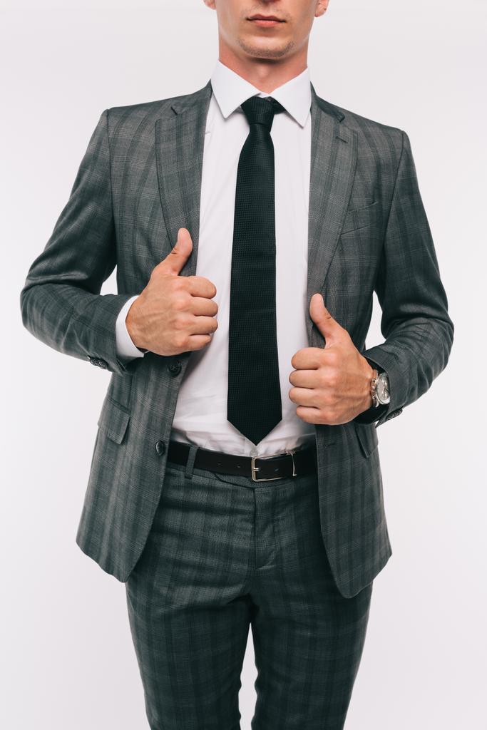 immagine ritagliata di uomo d'affari toccare giacca grigia isolato su bianco
  - Foto, immagini