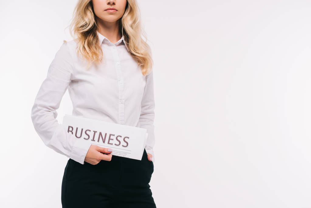 oříznutý obraz podnikatelka drží obchodní noviny izolované na bílém - Fotografie, Obrázek
