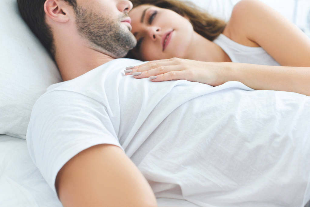 обрізаний знімок красивої молодої пари закоханих лежить разом у ліжку
  - Фото, зображення