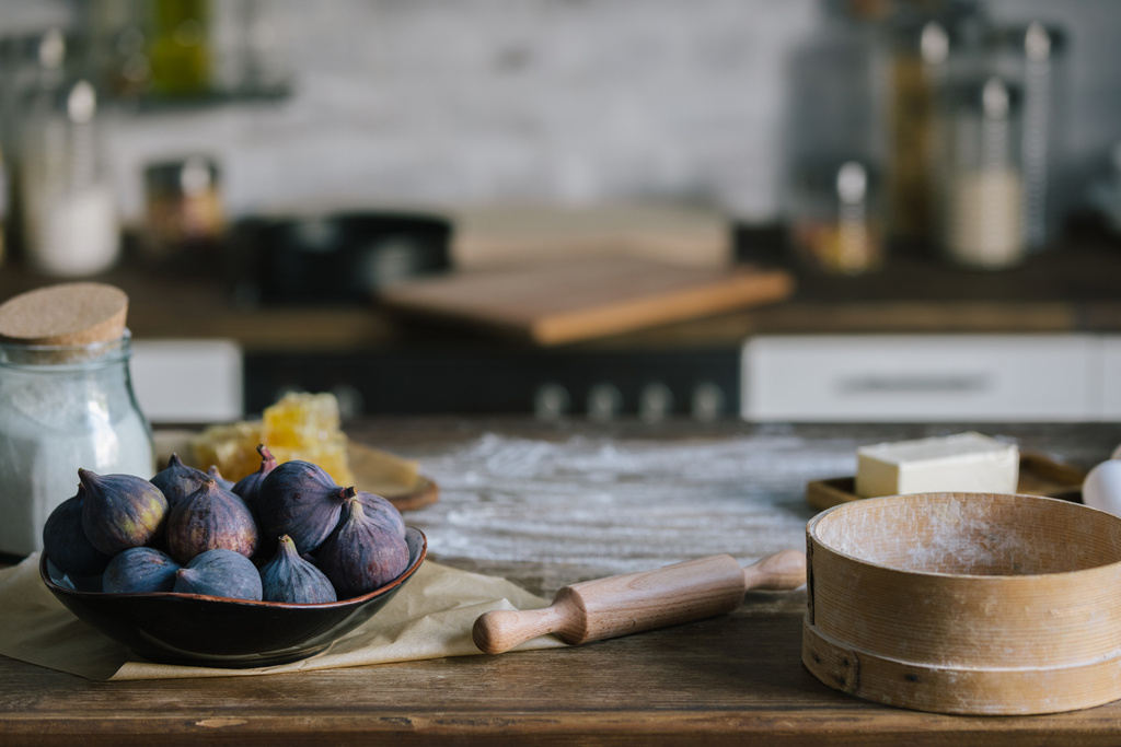 primo piano di ingredienti torta di fichi in piedi su un tavolo di legno rustico ricoperto di farina
 - Foto, immagini
