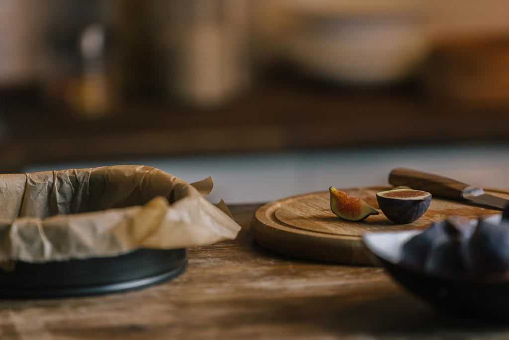 Figi z cięcia pokładzie i pieczenia formy pie na rustykalne drewniany stół - Zdjęcie, obraz