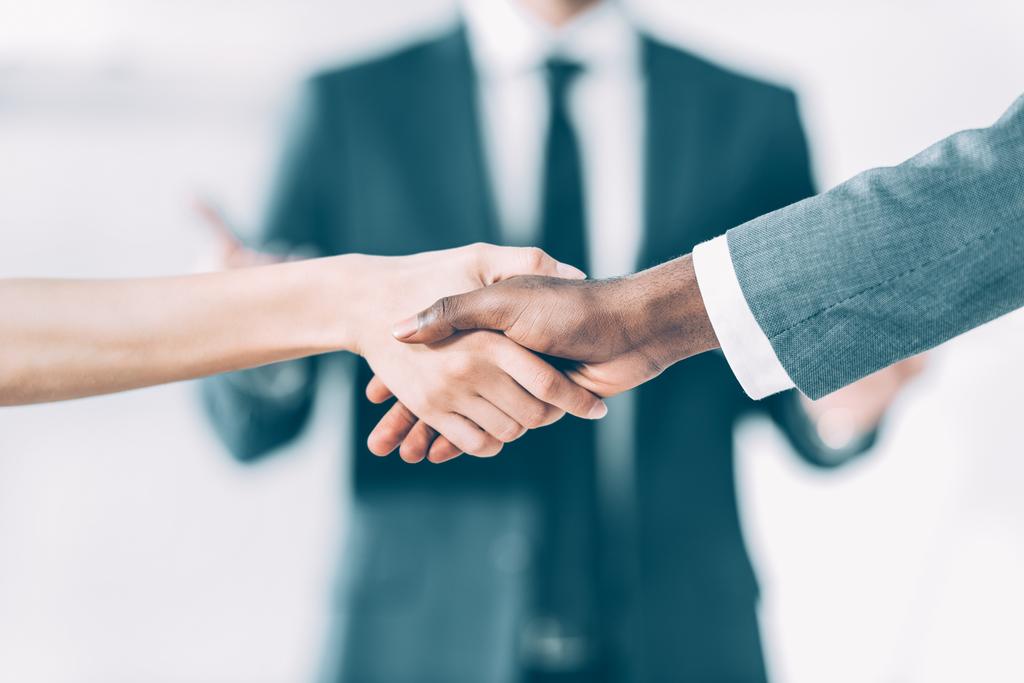 обрезанный снимок мультикультурных деловых партнеров мужчин и женщин, пожимающих друг другу руки
 - Фото, изображение
