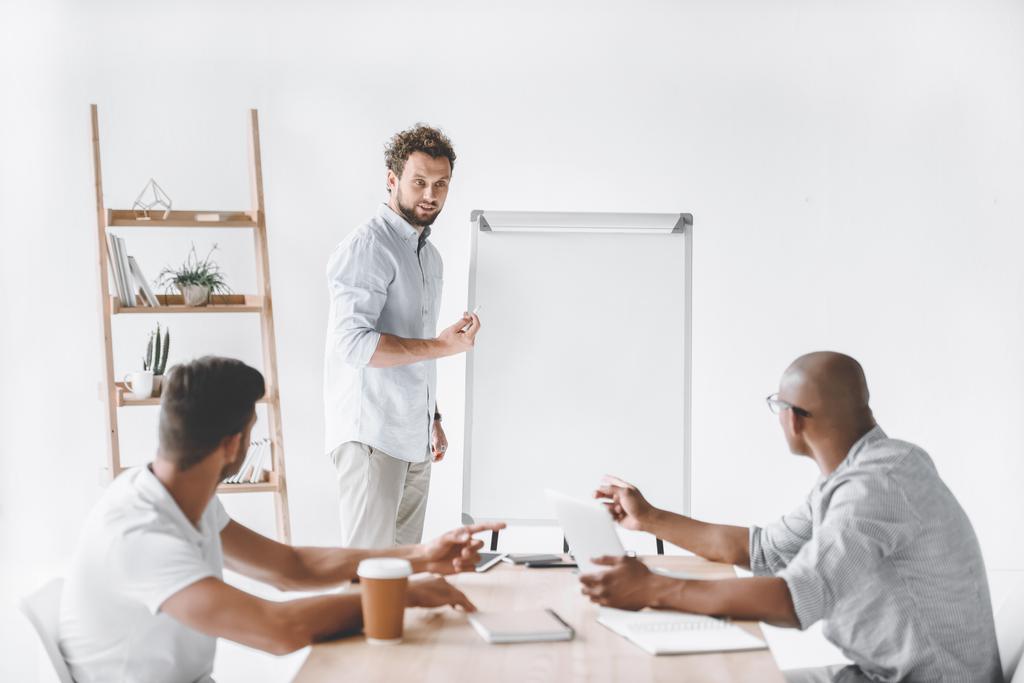 young businessman at white board making presentation to colleagues - Photo, Image