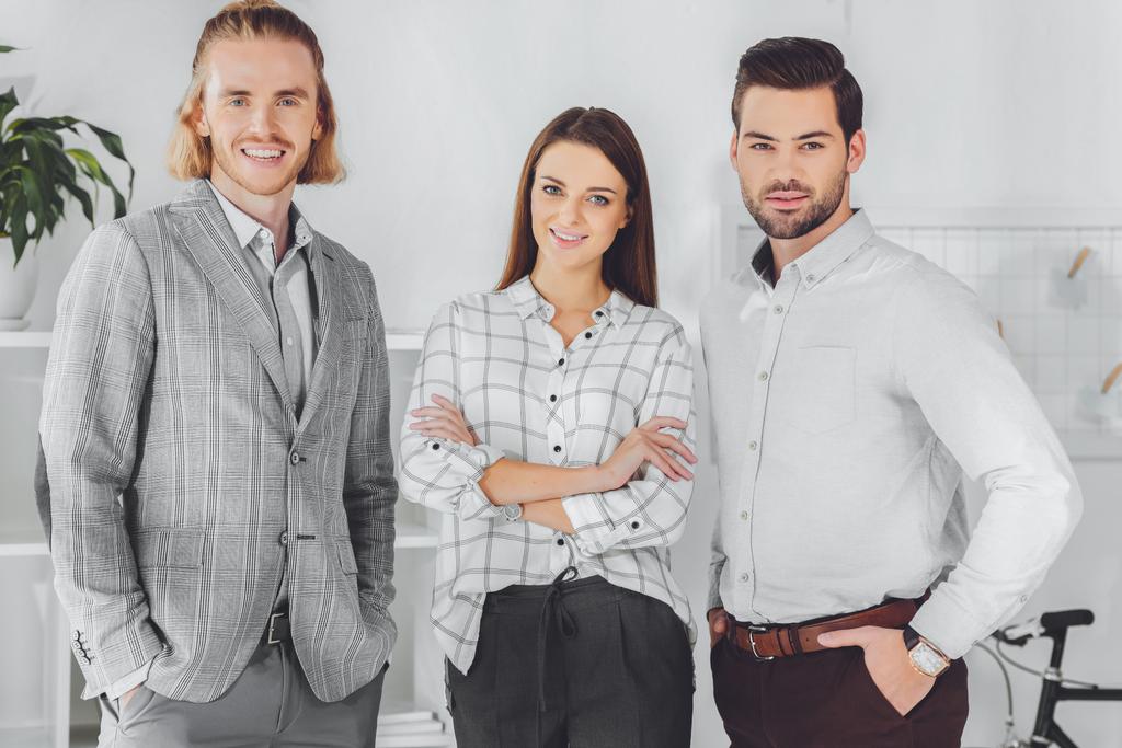smiling caucasian businesspeople standing in office and looking at camera - Photo, Image