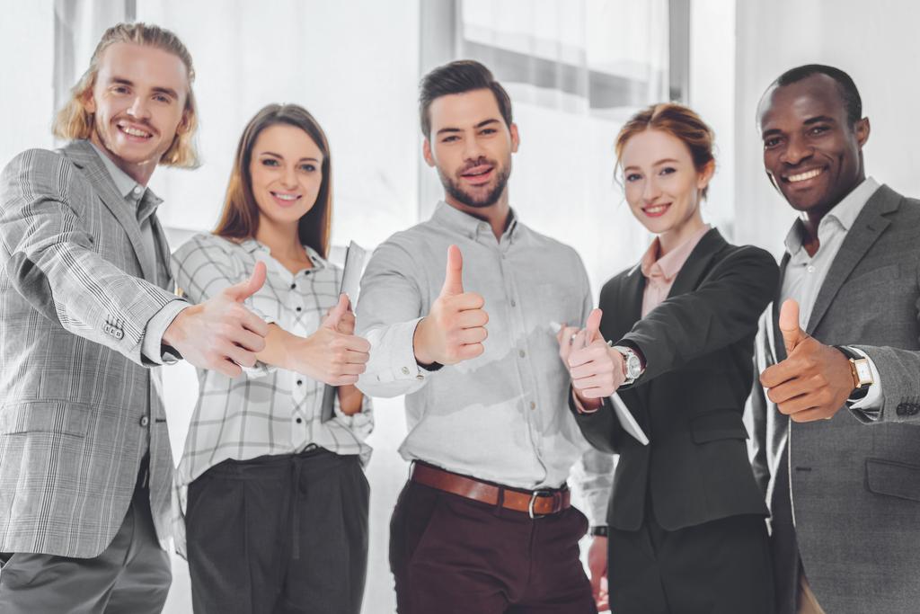 empresários multiculturais sorridentes mostrando polegares para cima
 - Foto, Imagem