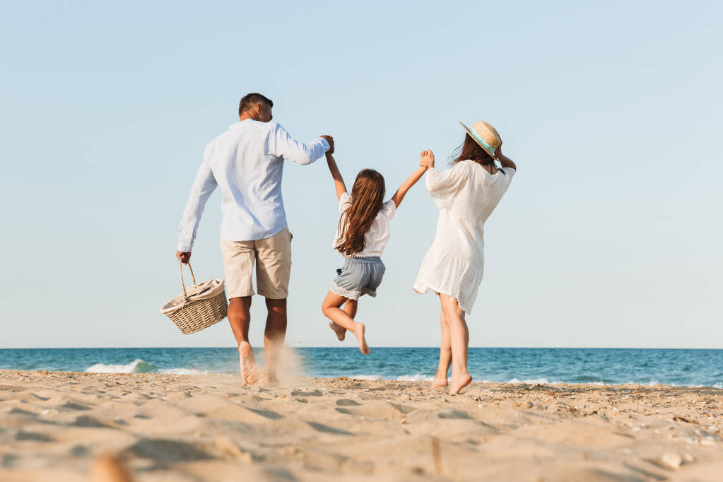 Φωτογραφία: νέοι χαριτωμένο ευτυχισμένη οικογένεια διασκεδάζοντας μαζί στην παραλία. - Φωτογραφία, εικόνα