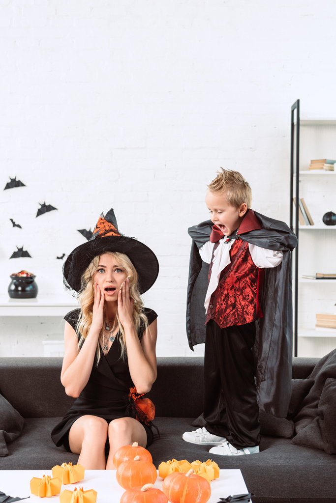 pieni poika vampyyri puku huutaa äidille noita halloween puku kotona
 - Valokuva, kuva