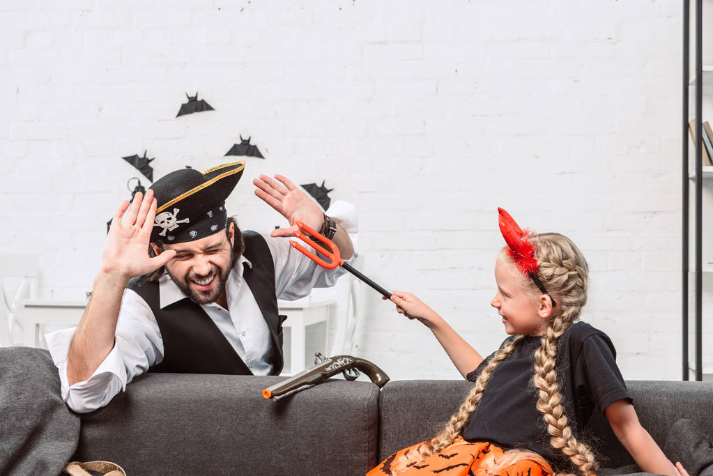 portrait of daughter and father in halloween costumes playing at home - Photo, Image