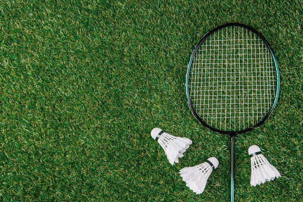 Układ płaski z badminton rakiety i lotki rozmieszczone na zielonej trawie - Zdjęcie, obraz