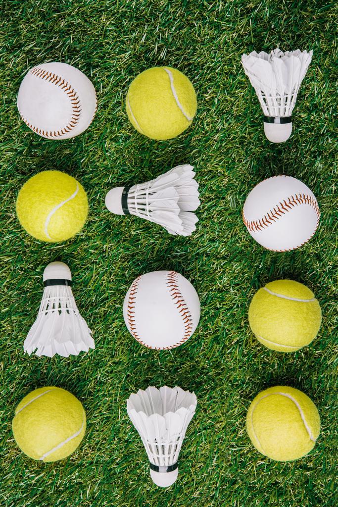 вид сверху на расположение шаттлов бадминтона, теннисных и бейсбольных мячей на зеленой лужайке
 - Фото, изображение