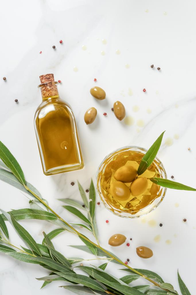 pohled shora na láhev a sklenice s olivovým olejem na mramorový stůl - Fotografie, Obrázek